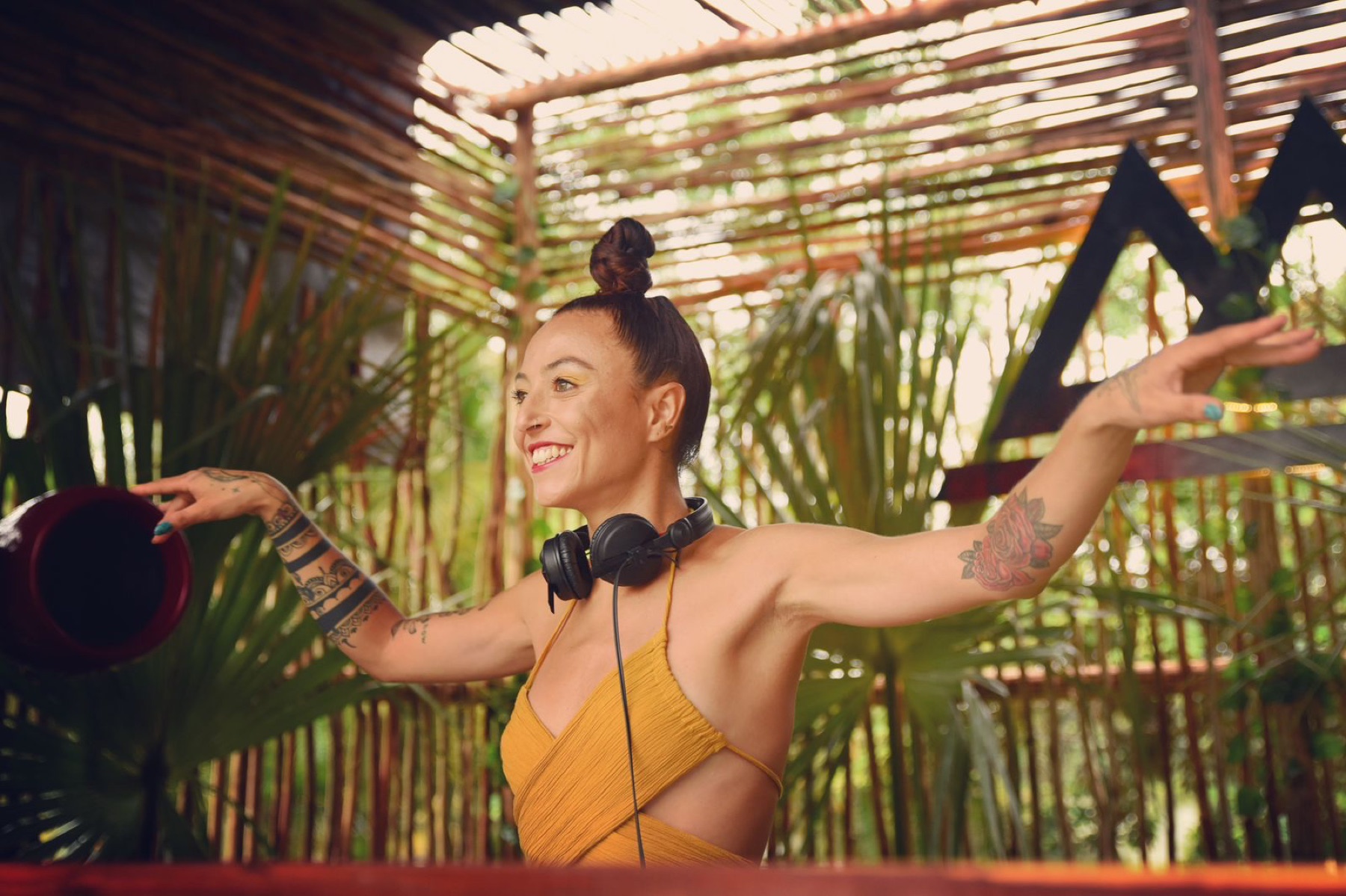 DJ at an outdoor set among palms