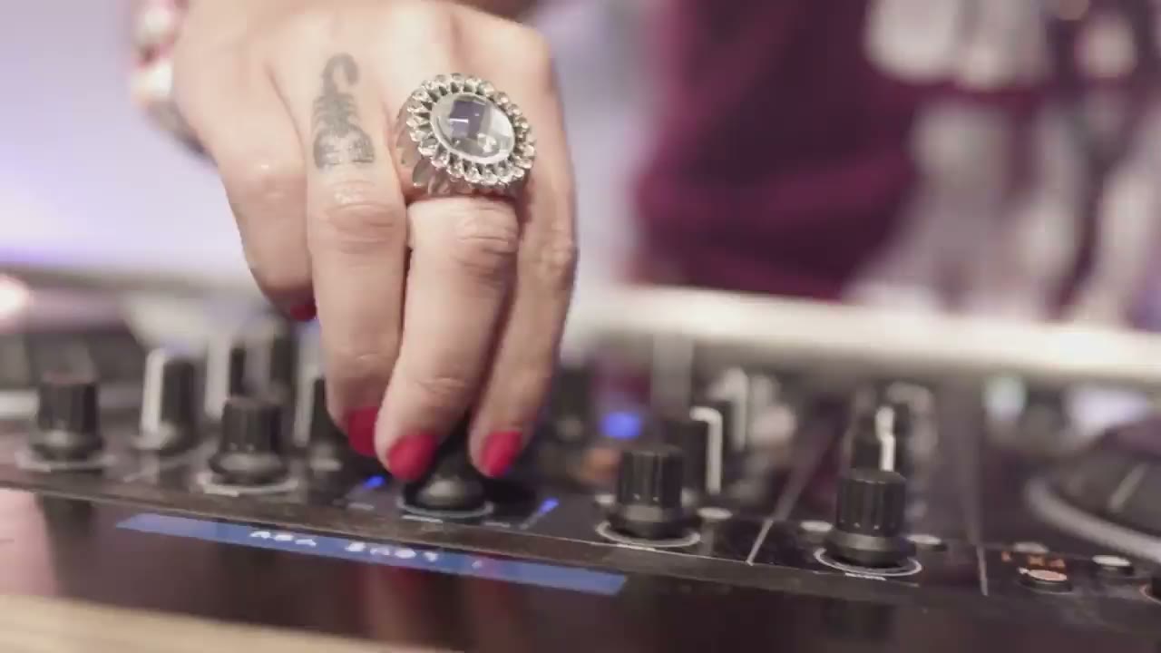 Female DJ performing at a beachfront wedding in Los Cabos at sunset