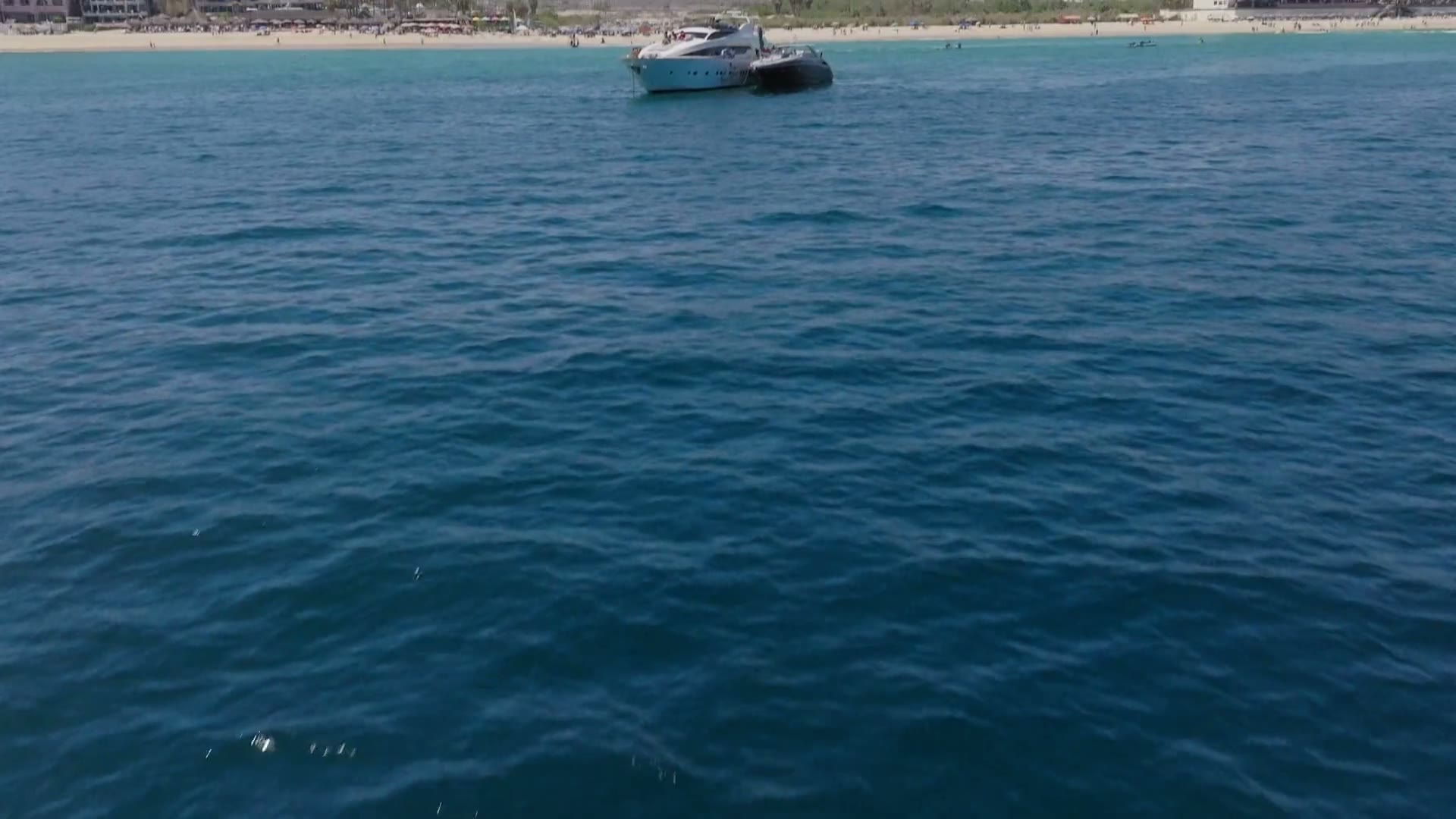 Female DJ playing a sunset set aboard a private yacht near the Arch, Cabo San Lucas